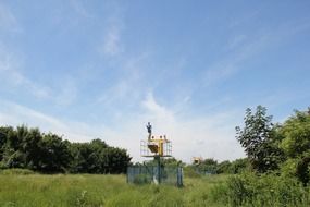 fenced tower on a green field