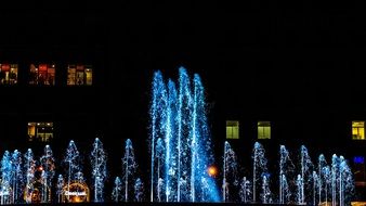 fountains in bright night illumination on the street of Barcelona