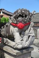statue of an ancient animal with a red ribbon