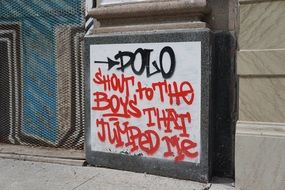 red and black graffiti on concrete wall