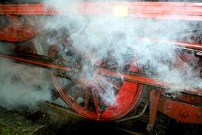 steam from the locomotive wheels