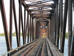 interior of old rusty railway bridge across river