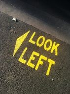look left, yellow marking on asphalt road