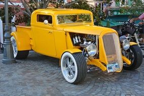 yellow vintage car on pavement at building