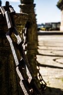 antique chain on column at street, spain, saint james compostela