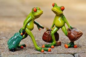 figures of frogs with suitcases