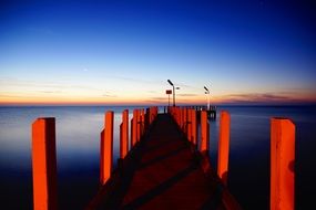 Pier wooden red illumination blue sky