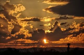 Colorful dawn among the clouds above the desert landscape