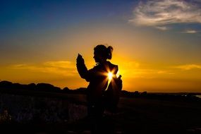 young woman silhouette at sunset sky