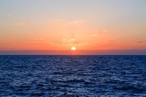 glow of pink sunset over ripples of the ocean