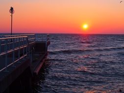 Beautiful and colorful sunrise over the ocean behind the pier