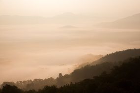 silhouettes of mountains in the clouds under the sunshine