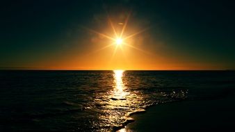 golden sun over the ocean in the dark