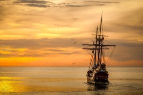 vintage ship on the water at sunset