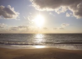 sandy beach and sun Shine on the sea waves