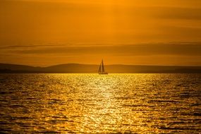 sailing boat at sea during sunset
