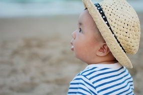 baby in a hat on the beach