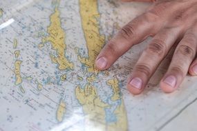 hand on sea map close up