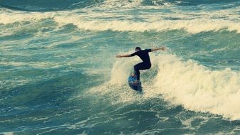 man swims through the waves on a surfboard