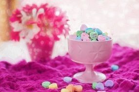 heart-shaped candies in a pink bowl