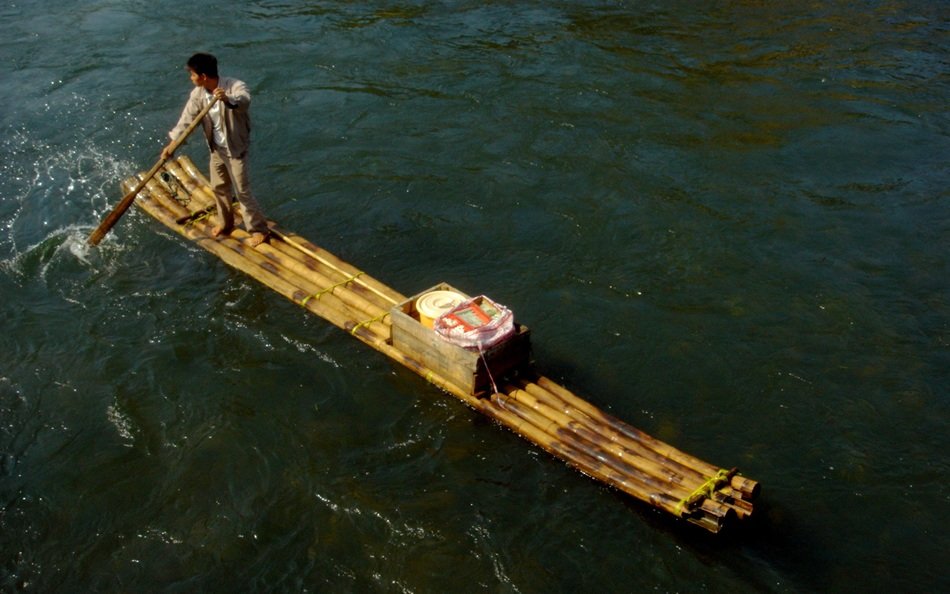man on bamboo raft in China