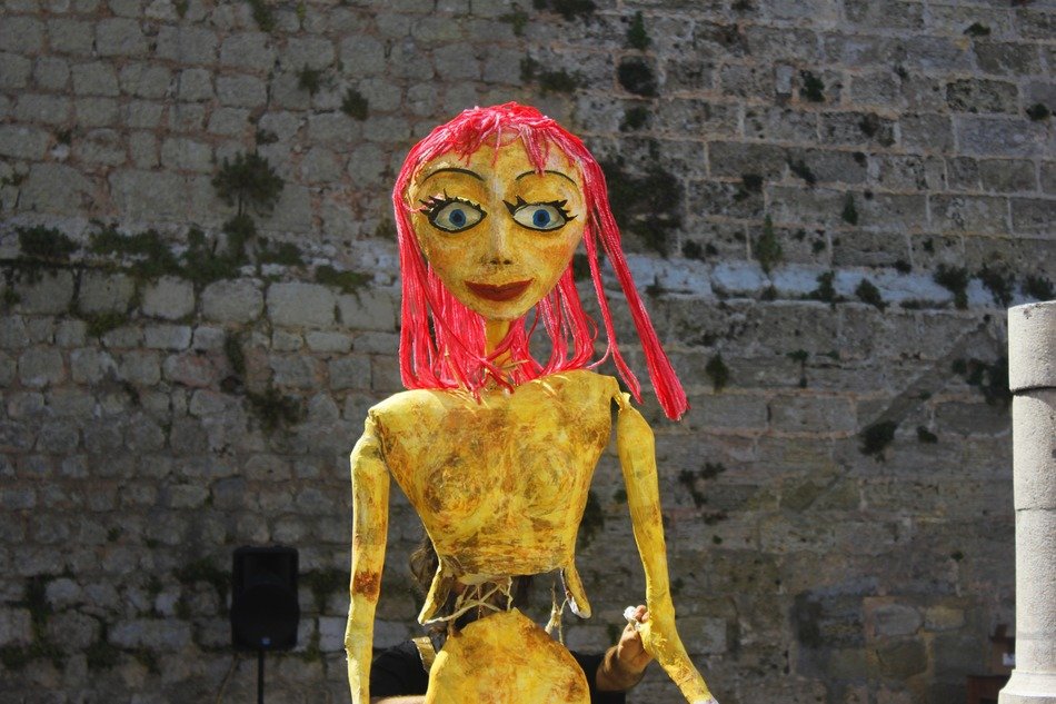 doll figure near the stone wall