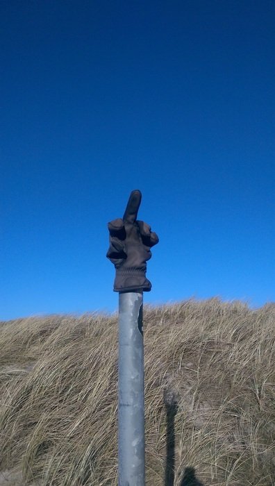 unusual road sign in the shape of the finger