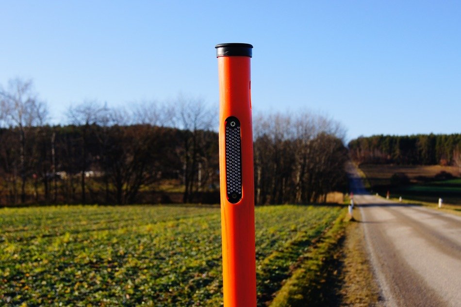 cat’s eye road post in countryside landscape