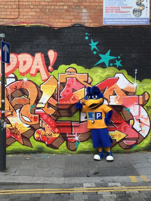 man in a suit near the wall with graffiti