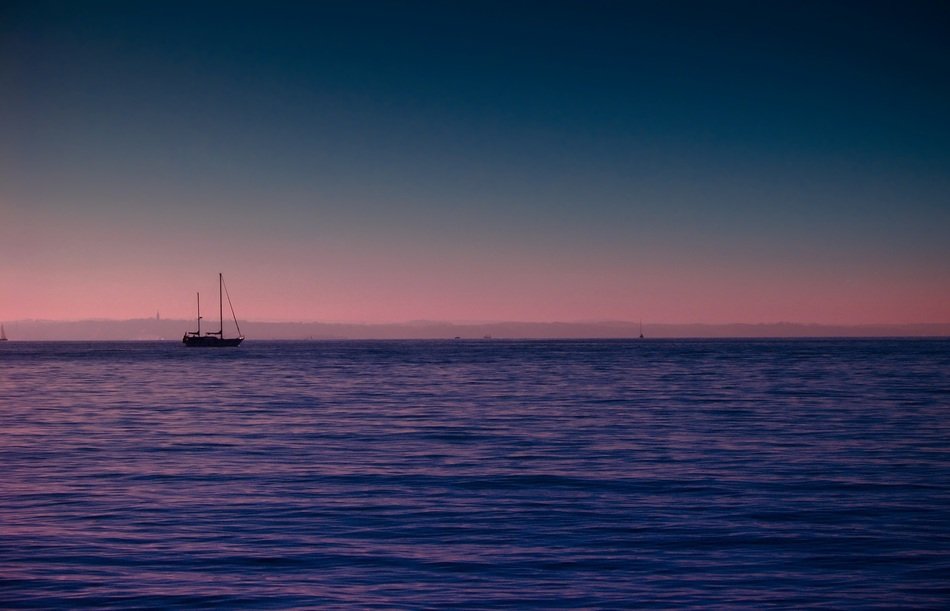sailing boat on the horizon in the ocean