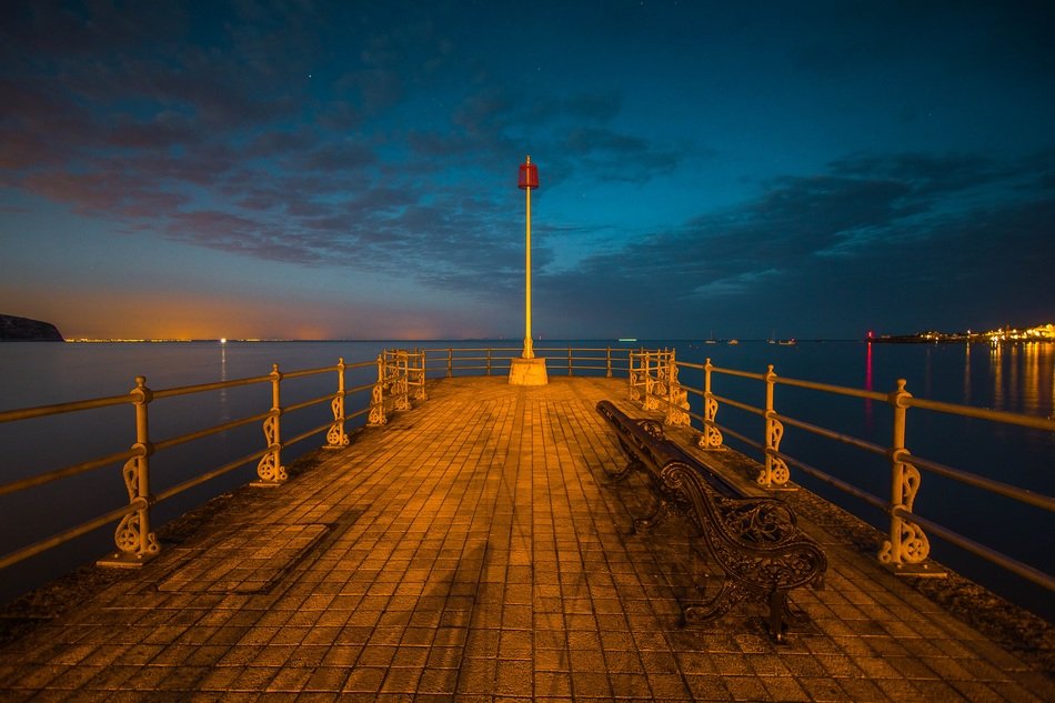cozy empty wooden bridge by the ocean at night