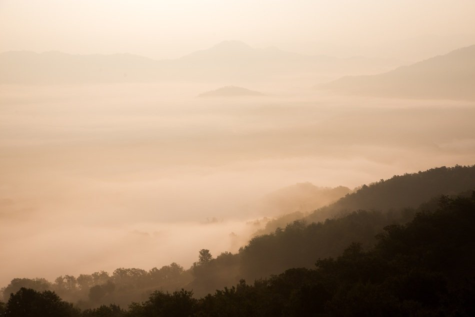 silhouettes of mountains in the clouds under the sunshine