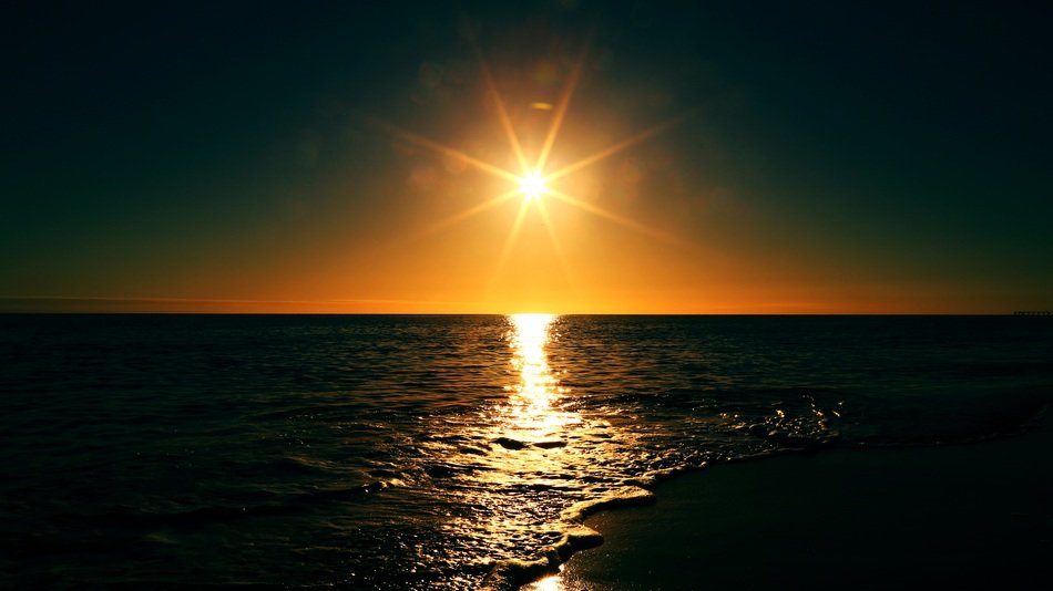 golden sun over the ocean in the dark
