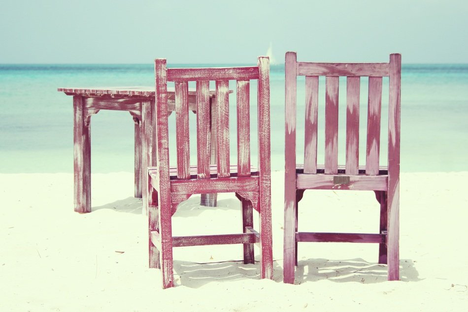 wooden table and chairs on the beach