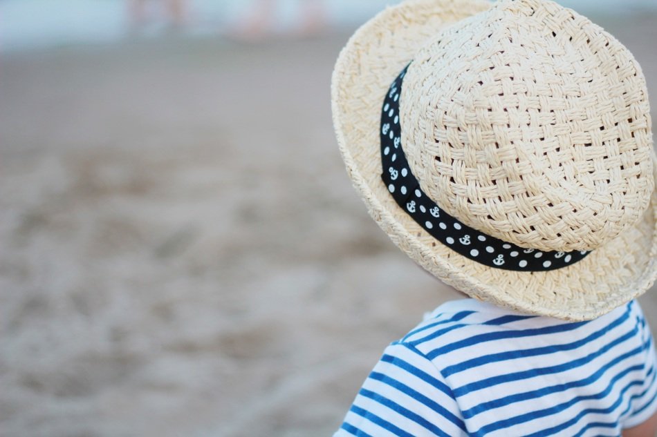 baby in hat on the beach
