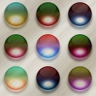 Nine colorful glass balls on brushed metal background