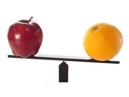red apple and orange on the scales