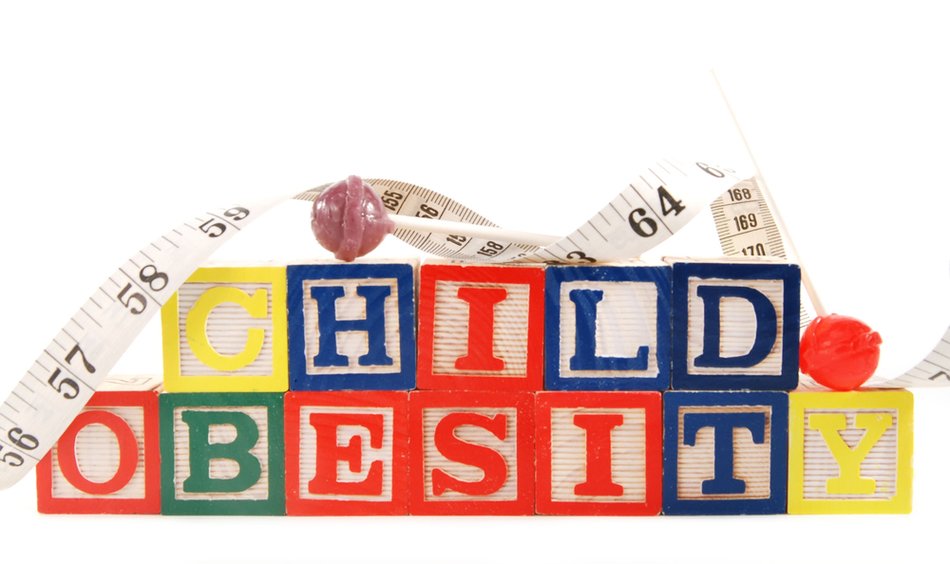 The Consequences And Risk Factors Of Childh Obesity, lollypops and measuring tape on colorful blocks with lettering