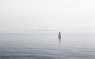 lonely grey tower in ocean water