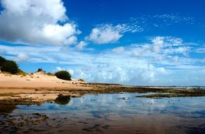 bright blue sky over water of sand lagoon