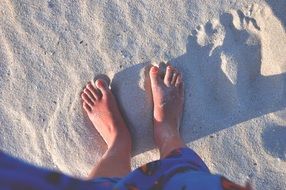 female feet in the sand on the beach close up