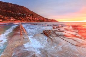 sea waves on the sand coast shore at sunset