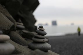 stacks of stones showing the way on beach, iceland