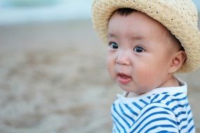cute baby in straw hat on the beach