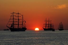 big sailing ships at sunset sea