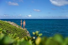 Man and woman staying on rock near the sea