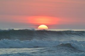 Orange sunset ocean white water waves tropical