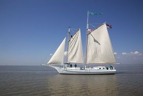 wooden ship with white sails at sea