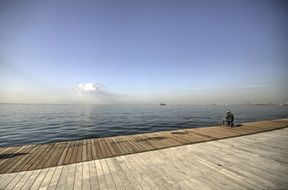 lone fisherman on the ocean promenade