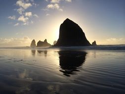 haystack rock in ocean at sunset, usa, oregon